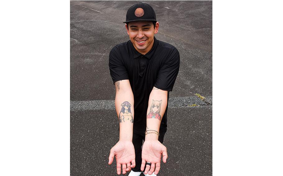 Luis shows his tattoos on his arms.