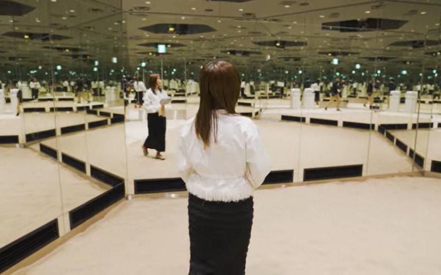 A woman walks on a shared sand-themed exhibit.
