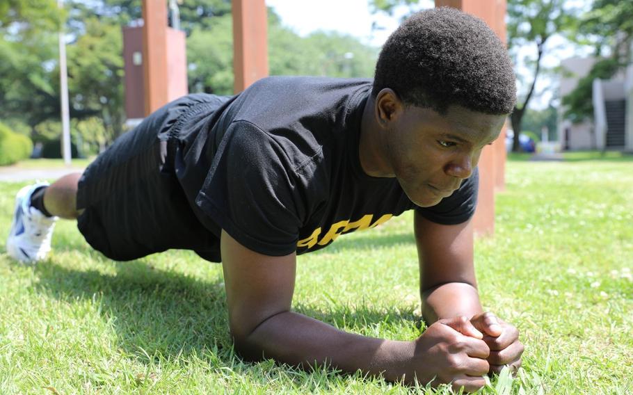 Franck Karel Penga Nkweya does a plank exercise on the lawn.