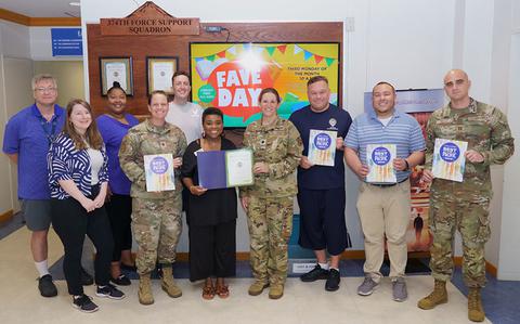 Photo Of Yokota FSS staff group photo as Stars and Stripes Pacific Commander Lt. Col. Marci Hoffman presents award.