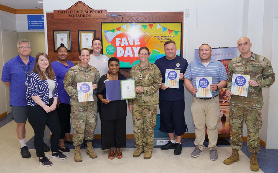 Yokota FSS staff group photo as Stars and Stripes Pacific Commander Lt. Col. Marci Hoffman presents award.