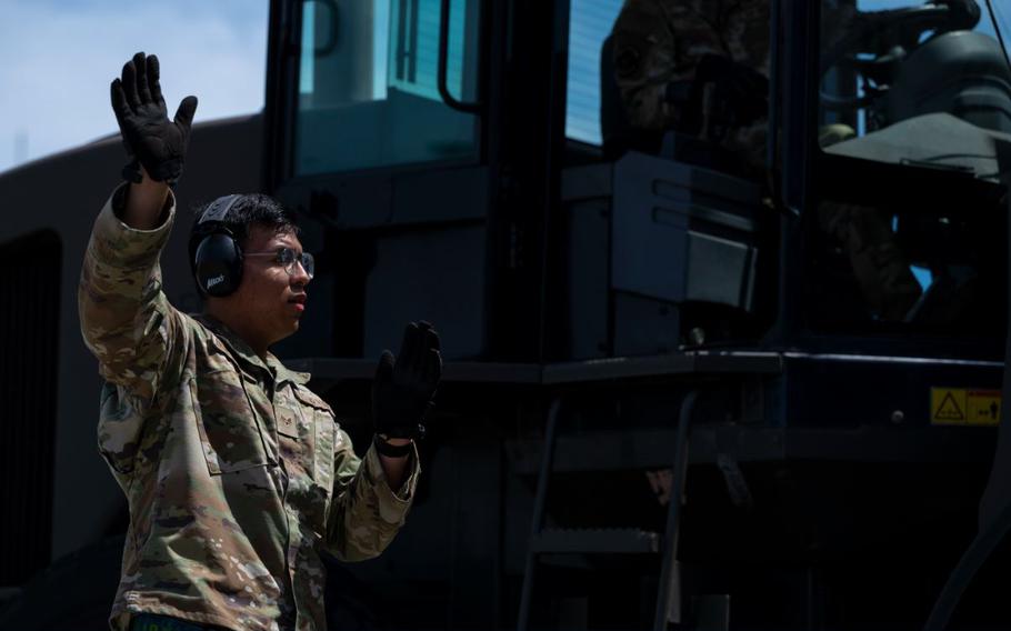 U.S. Air Force Senior Airman Yordi Andres Juarez provides signals during a cargo movement.