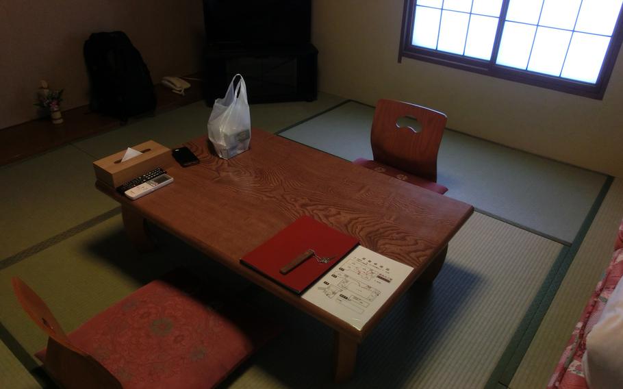 Japanese style room with tatami mat, legless chairs and low table.