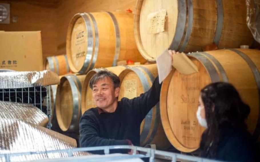 The winery staff member explains about wine to the participanes.
