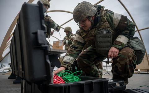 Photo Of Senior Airman Jack Miesse packs up a spoke communication framework.