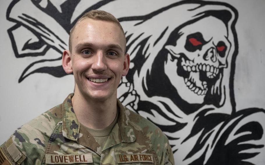 2nd Lt. Nathan Lovewell poses for a photograph in front of a mural of the 35th LRS mascot.