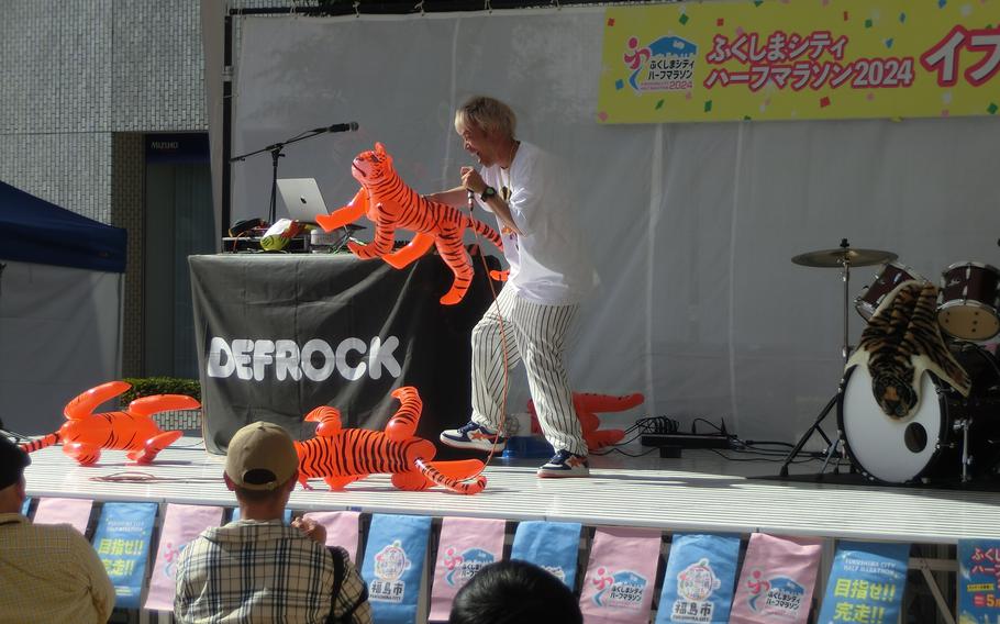 A musician singing with tiger-shape balloon on his hand.