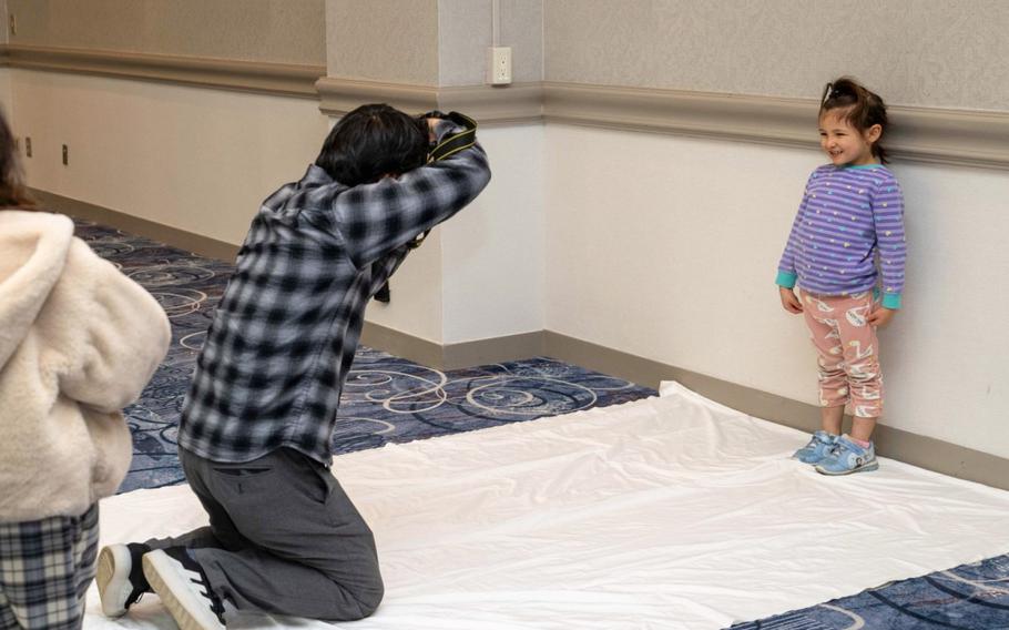 A young community member has her photo taken by a talent and model agency.