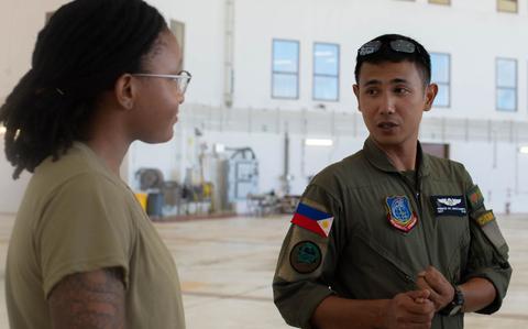 Photo Of 1st Class Kalaia Davis speaks with Philippine Air Force Sergeant Prince Deocampo.