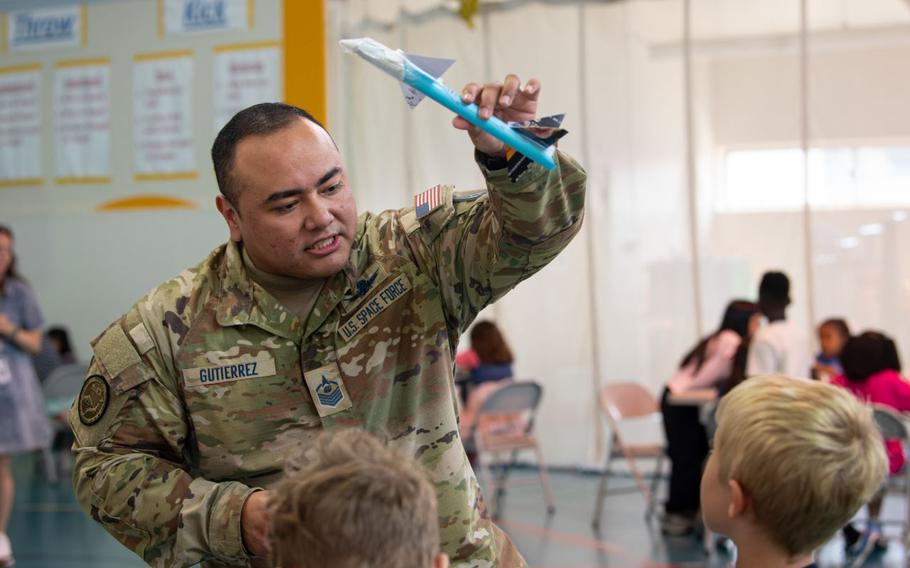 U.S. Space Force Master Sgt. Paul Gutierrez, U.S. Space Forces-Japan missile warning advisor, demonstrates a rocket launch to students from Yokota West Elementary School.