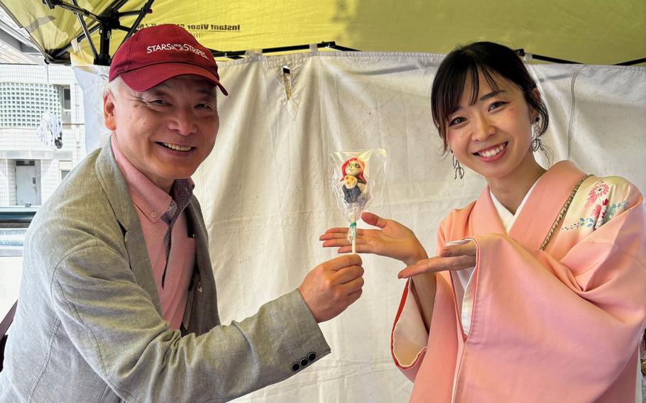 Candy artist and the author showing a candy.