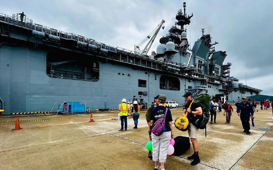 The USS Tripoli has just arrived at Juliet Pier at CFAS, with sailors disembarking from the ship. USO volunteer Geri Haradon is on hand, ready to provide information and assistance to our service members.