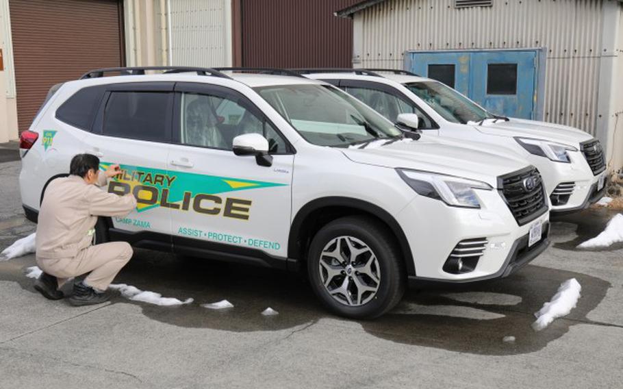 Hiroyuki Takahashi, an electronic mechanic with Logistics Readiness Center-Honshu, smooths over a decal on a new military police vehicle at Sagami General Depot, Japan, Feb. 7, 2024. U.S. Army Garrison Japan worked with partners to receive 12 patrol vehicles following a lengthy procurement process.