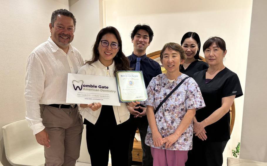 Womble Gate American Dentistry staff group photo as Stars and Stripes Pacific Max Genao presents award.