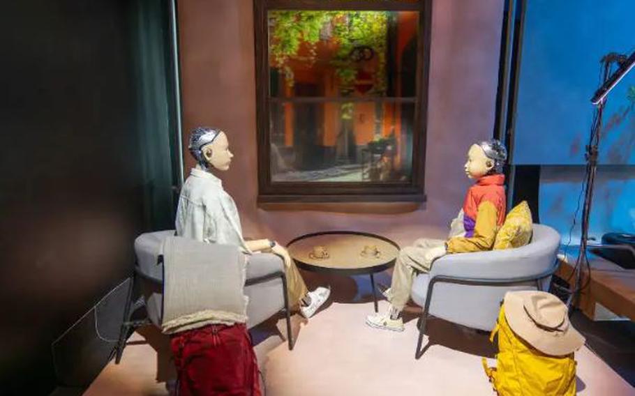 two androids sitting and looking at each other