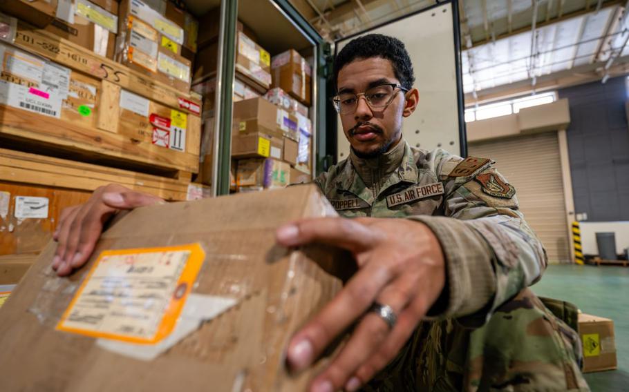 Squatting down, Senior Airman Djavion Poppell conducts an inventory of aircraft maintenance items for Operation Christmas Drop 2024 at Yokota Air Base, Japan.