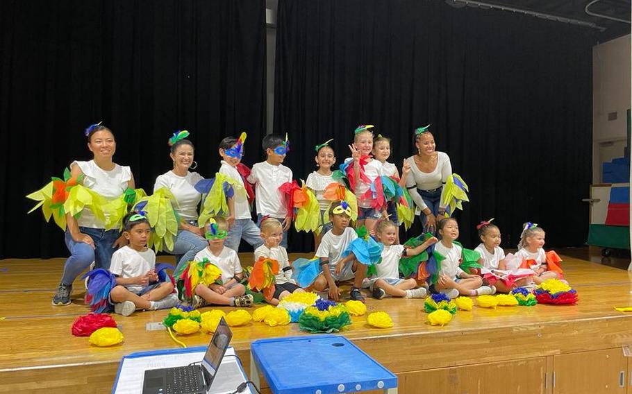 kids and adults pose on the stage.