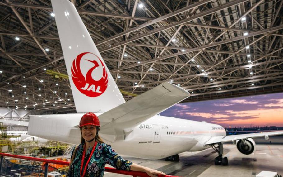 a woman poses in front of the hangar.