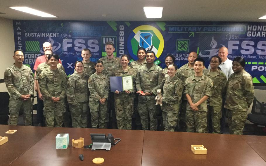 Misawa FSS staff group photo as Stars and Stripes Pacific Commander Lt. Col. Marci Hoffman presents award.