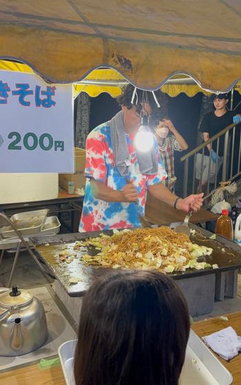 A booth staff member makes yakisoba.