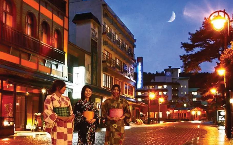 Three women pose for a photo on the street.