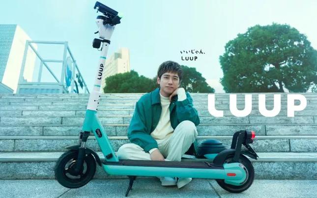 Kazunari Ninomiya sitting next to a LUUP e-scooter.