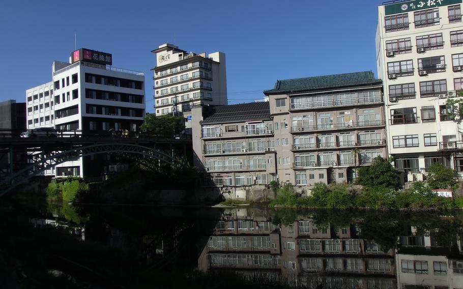 Hotels are reflected on the river.