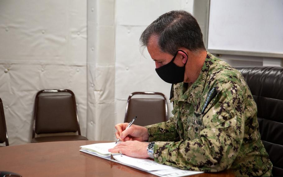 Rear Adm. Michael Donnelly, Commander, Task Force 70, signs a document during the 30th U.S.-Republic of Korea Composite Warfare Commander Meeting, conducted via teleconference from Yokosuka Naval base, as part of the bi-annual tradition, Feb. 9. CTF 70 is forward-deployed to the U.S. 7th Fleet area of operation in support of a free and open Indo-Pacific. (U.S. Navy photo by Mass Communication Specialist 2nd Class Askia Collins)