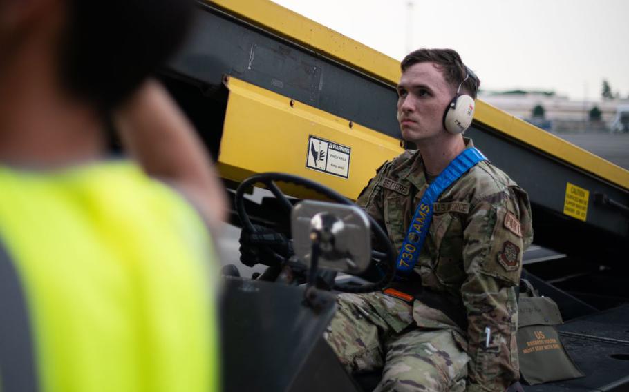 U.S. Air Force Airman 1st Class Tristan Betterelli, 730th Air Mobility Squadron air transportation specialist, guides a luggage-loading vehicle into position at Yokota Air Base, Japan, Aug. 5, 2024.