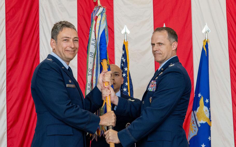 From the left, U.S. Air Force Col. Andrew Roddan, 374th Airlift Wing commander, presents the 374th Operations Group guidon to Col. Nathan Powell, 374th OG incoming commander, as they take command during a change of command ceremony at Yokota Air Base, Japan, June 14, 2024.