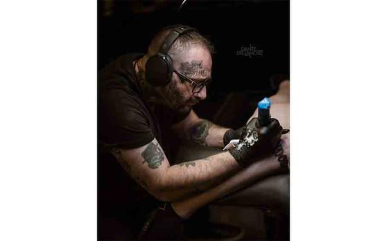 Photo Of Lord Grim drawing a tattoo