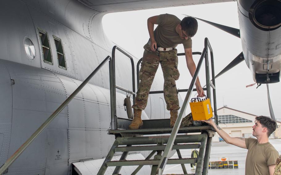 U.S. Air Force Airman 1st Class Cameron Theede hands off a fuse box to Senior Airman Brayden Forehand as they load temporary countermeasure chaff and flares in response to a simulated scenario during exercise Beverly Morning 25-1.