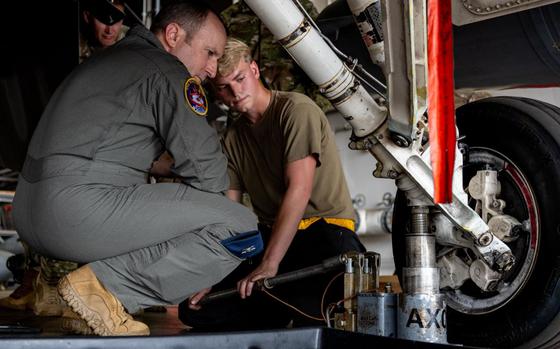 U.S. Air Force Col. Matthew Kenkel, left, 35th Fighter Wing deputy commander, and Senior Airman Derek Johnson, 14th Fighter Generation Squadron F-16 Fighting Falcon assistant dedicated crew chief, inspect the wheel of an F-16 during a brake pad change at Misawa Air Base, Japan.