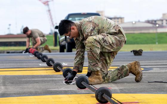 Photo Of Senior Airman Branson Sutherland, 374th CES power production journeyman, ties a knot on the flightline aircraft arresting system for an annual recertification test at Yokota Air Base, Japan, Oct. 7, 2024.