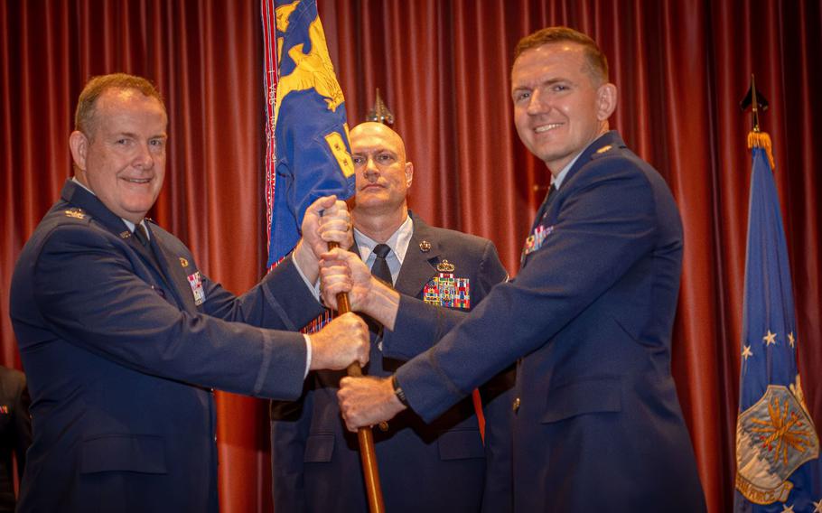 From the left, U.S. Air Force Col. Sean McKenna, Pacific Air Forces public affairs director, presents the guidon to incoming commander, Lt. Col. Joseph Hansen during a change of command ceremony at Yokota Air Base, Japan, June 14, 2024.