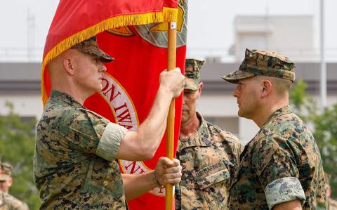 Photo Of U.S. Marine Corps Col. Kenneth Rossman, left, oncoming commanding officer, Marine Corps Air Station Iwakuni, takes the station colors from Col. Richard Rusnok, right, outgoing commanding officer, MCAS Iwakuni, during a change of command ceremony at MCAS Iwakuni, Japan.