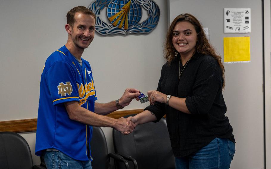 U.S. Air Force Staff Sgt. Kayla Ludwigsen, 35th Comptroller Squadron financial analysis supervisor, is coined by Col. Michael Richard, 35th Fighter Wing commander, at Misawa Air Base, Japan, Sept. 30, 2023. The 35th Comptroller Squadron oversees the finances of Misawa Air Base personnel and equipment. (U.S. Air Force photo by Airman 1st Class Koby Mitchell)