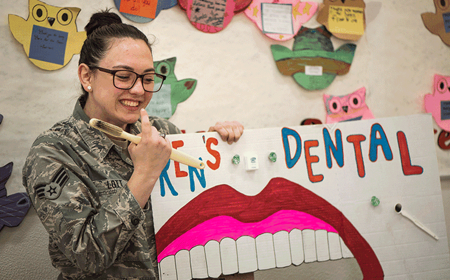 U.S. Air Force Senior Airman Courtney Lott, a 35th Dental Squadron dental technician, points to her teeth during a National Dental Health Month workshop at Misawa Air Base, Japan, Feb. 26, 2019. This event provided models for children to apply the techniques shared about proper oral hygiene. (U.S. Air Force photo by Airman 1st Class Collette Brooks)