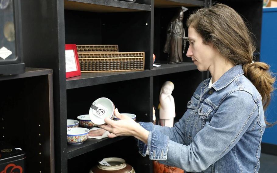 Angela Heck, president of the Zama Community Spouses’ Association, cleans a shelf April 17 at the East Meets West Gift Shop on Camp Zama.