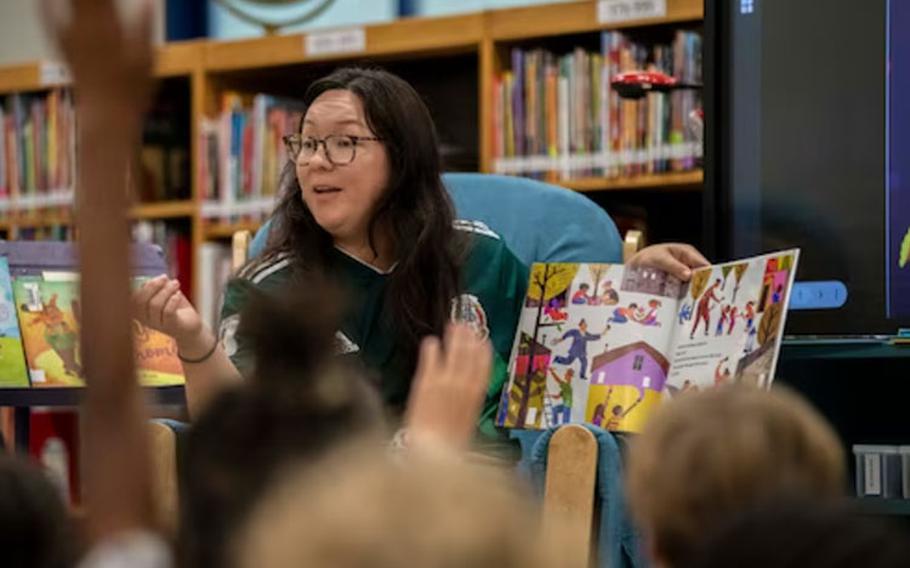 Danielle Gomez, Yokota Latin American Association (LAA) secretary, points to a student during a Hispanic Heritage Month read aloud at Yokota Air Base, Japan, Sept. 20, 2023. The Yokota LAA is a private organization dedicated to representation, community, and empowerment for Latin culture at Yokota. (U.S. Air Force photo by Airman 1st Class Samantha White)