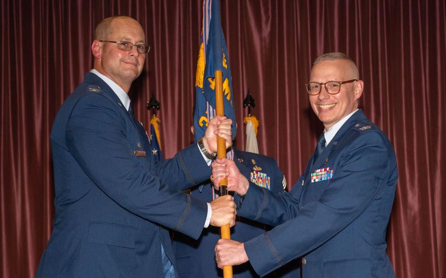 U.S. Air Force Col. Richard McElhaney, 374th Airlift Wing commander, presents the unit guidon to Col. Graham Warden, 374th Medical Group incoming commander, during the 374 MDG change of command ceremony at Yokota Air Base.