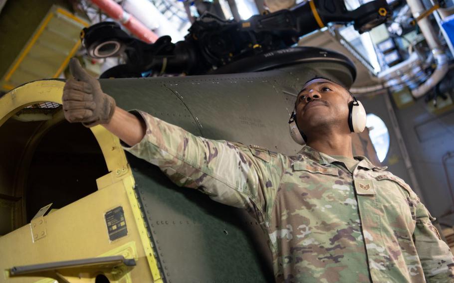 U.S. Air Force Staff Sgt. Eric Shaah, left, 730th Air Mobility Squadron air transportation specialist, gives the thumbs-up to Japan Ground Self-Defense Force soldiers assigned to the 1st Helicopter Brigade during a C-17 static loading test in support of Keen Sword 25 at Naval Air Facility Atsugi, Japan.