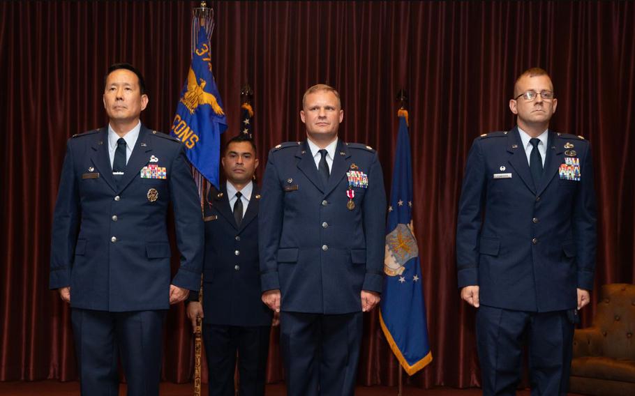 From the left, U.S. Air Force Col. Burt Okamoto, 374th Mission Support Group commander; Lt. Col. Mark Wagner, 374th Contracting Squadron outgoing commander; and Lt. Col. Scott Schneider, 374th CONS incoming commander, stand at attention during a change of command ceremony at Yokota Air Base, Japan, July 16, 2024.