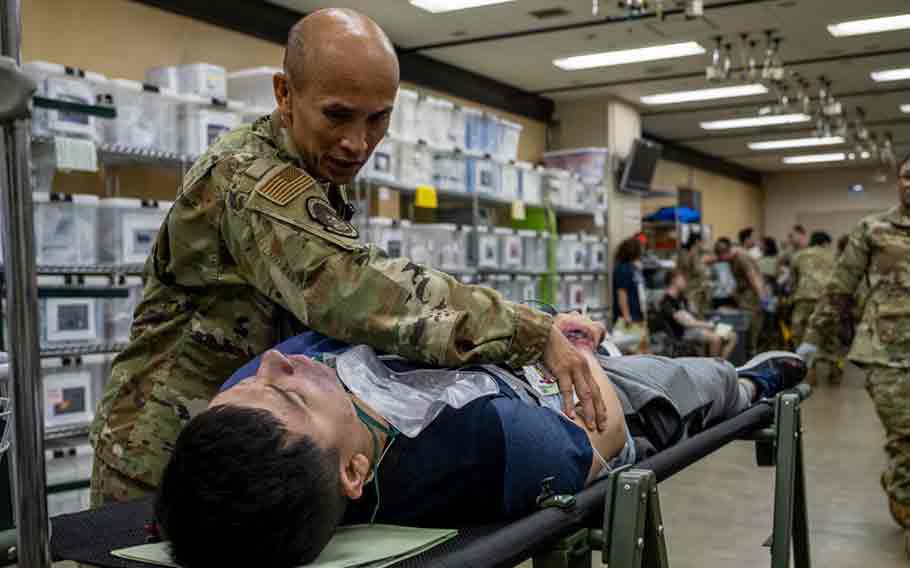 U.S. Air National Guard Maj. Hung Bui, 141st Medical Group nurse, simulates medical response for casualty actor U.S. Air Force Airman 1st Class Andre Medina, 35th Fighter Wing Public Affairs apprentice, during an Emergency Management exercise at Misawa Air Base, Japan, Aug. 28, 2024.