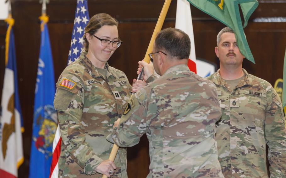 Capt. Sarah Baermann receives the 901st Military Police Detachment guidon from U.S. Army Garrison Japan Commander Col. Christopher Tomlinson during a change-of-command ceremony June 21 at Camp Zama’s Kizuna Hall. Baermann took command of the 901st and 88th Military Police Detachments from outgoing commander Capt. James Martin during the ceremony. (Momoko Shindo, U.S. Army Garrison Japan Visual Information Division)