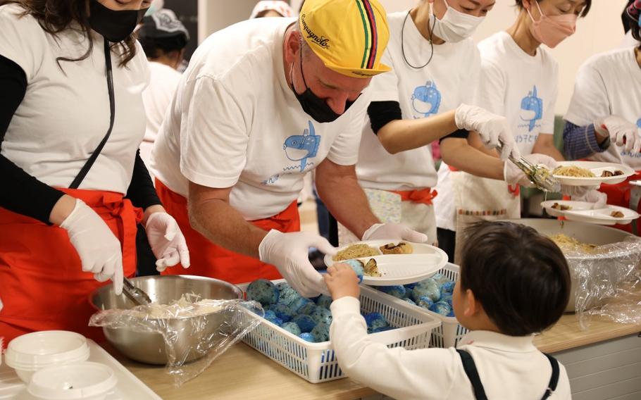 Jim McGee, left, the chief of U.S. Army Garrison Japan’s Visual Information Division at Camp Zama, Japan, serves food to a child Nov. 22 with other local volunteers at the Manbow Children’s Cafeteria in Setagaya, Tokyo. (Noriko Kudo, U.S. Army Garrison Japan Public Affairs)