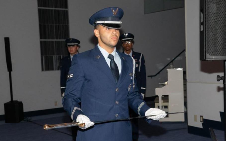 U.S. Air Force Airman 1st Class Renny Rodriguez, base honor guardsman, holds the 374th Airlift Wing sword during the 77th Air Force Ball cake-cutting ceremony at Yokota Air Base, Japan, Oct. 5, 2024.