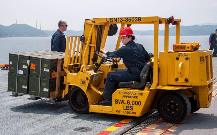 Aviation Ordnanceman 2nd Class Michelle Tucker, from Splendora, Texas, assigned to the forward-deployed amphibious assault carrier USS America (LHA 6), operates a forklift to guide ordnance during an ammunition handling evolution in Sasebo bay June 11.