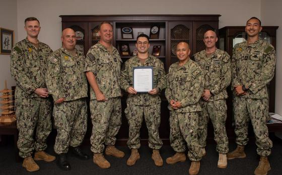 Photo Of Fire Controlman Aegis 1st Class Clarence Lamont, assigned to Commander, Fleet Activities Sasebo (CFAS) poses for a group photo with the CFAS command triad and Sailors after Lamont had received news that he was chosen as the 2024 U.S.-Japan Navy Friendship Association (JANAFA) Award Winner at CFAS, Oct. 16, 2024.