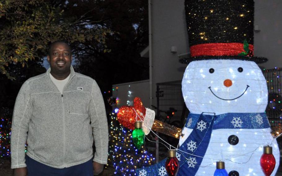 Parish Jones, who decorates his yard extensively for the holidays, poses for a photo at his home at Sagamihara Family Housing Area, Japan, Dec. 13. (Photo Credit: Winifred Brown)